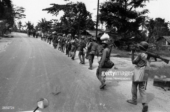 Troops from the Nigerian Federal Army marching along a road after routing Biafran troops at Port Harcourt during the Biafran War.